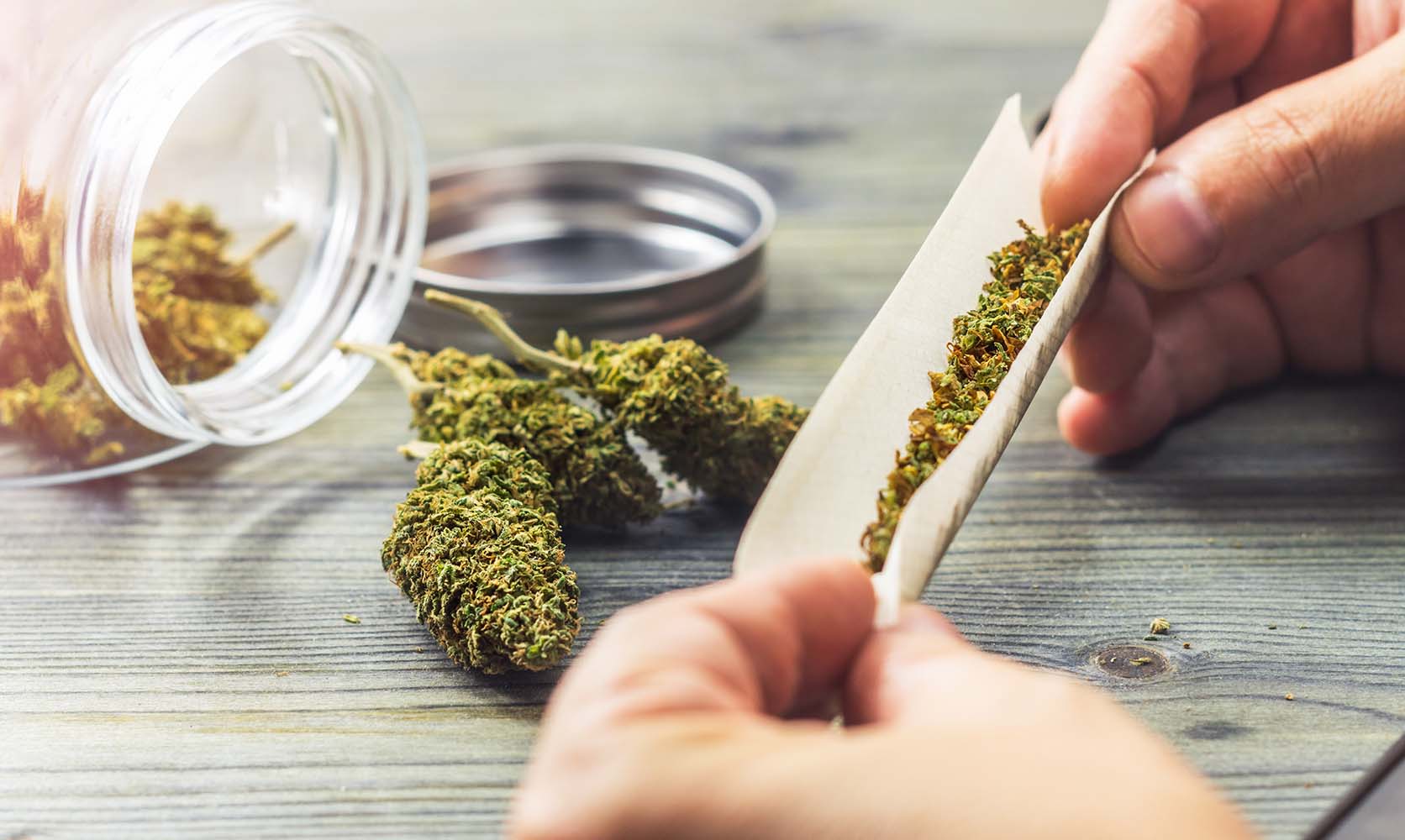 man rolling a joint with a grinder. how to grind Weed Without A Grinder.