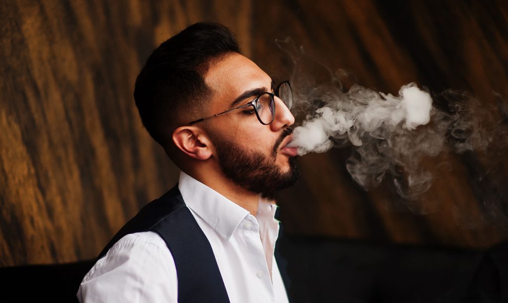 man with glasses blowing vape clouds. what is dabbing?
