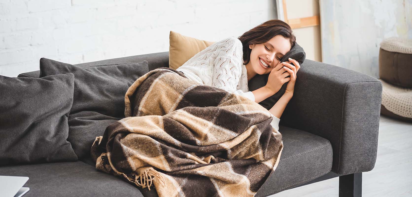 Smiling lady sleeping soundly on her sofa at home after buying Garlic Cookies strain weed online from West Coast Cannabis Canada online dispensary.