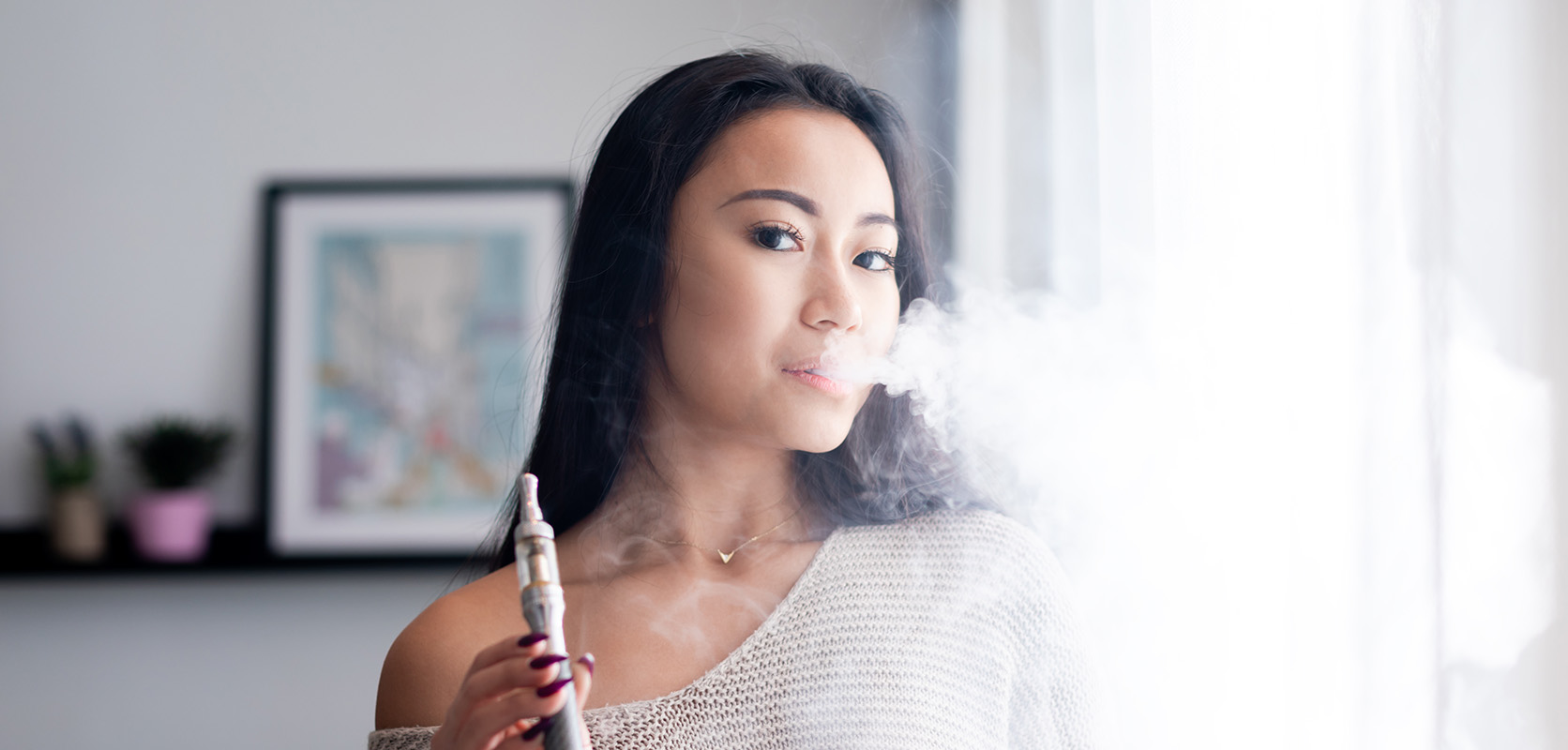 Woman blowing vape clouds after smoking wax from a dab pen. Buy weed online in Canada from the top online dispensary for weed online.