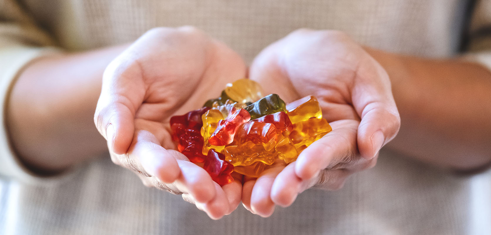 Selection of THC gummies cupped in the hands of a man.