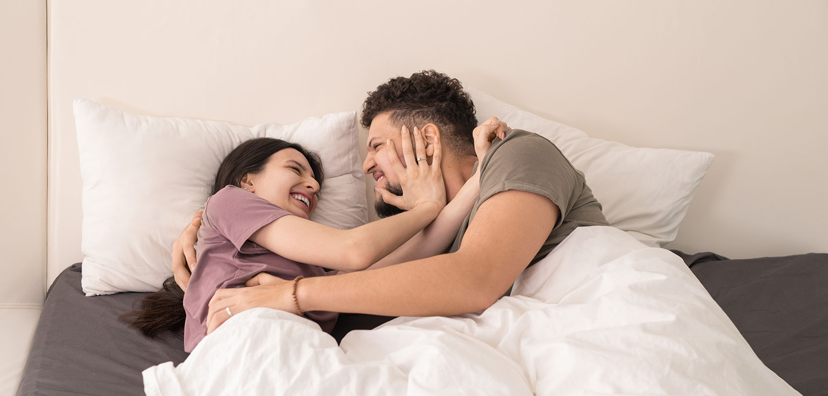 Adult couple laughing in bed. what is the best weed for sex? online dispensary canada. buy online weeds. weed online canada.