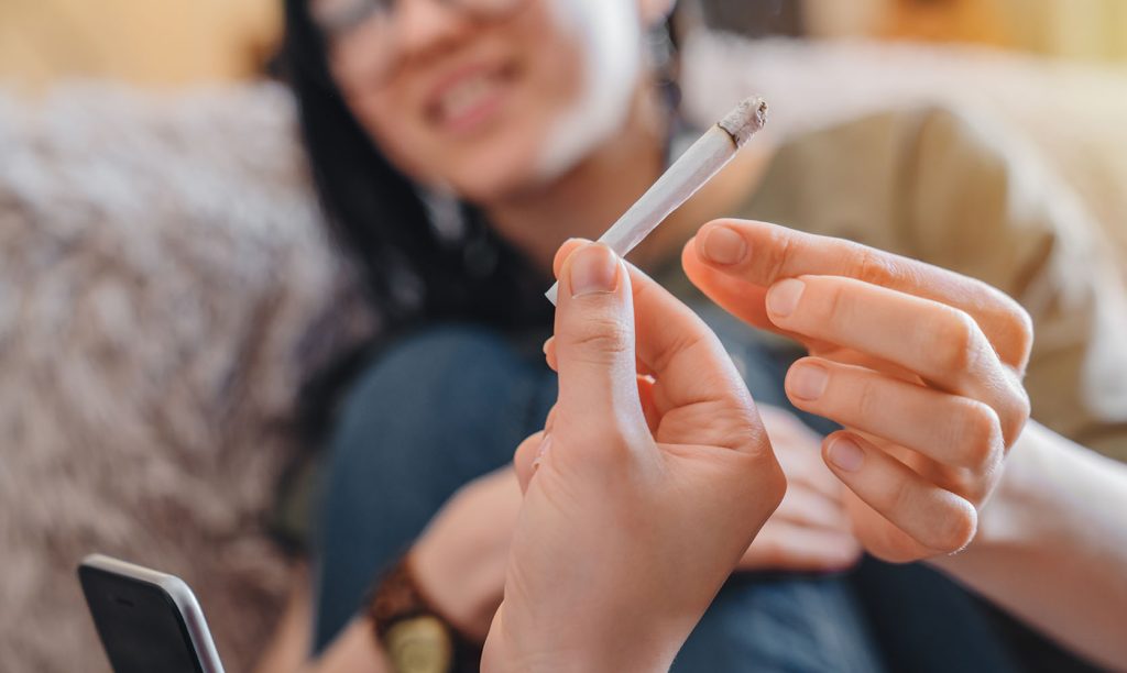 Friends using proper weed etiquette to pass a joint. online dispensary canada to buy weeds online. cannabis canada. Dispencary.