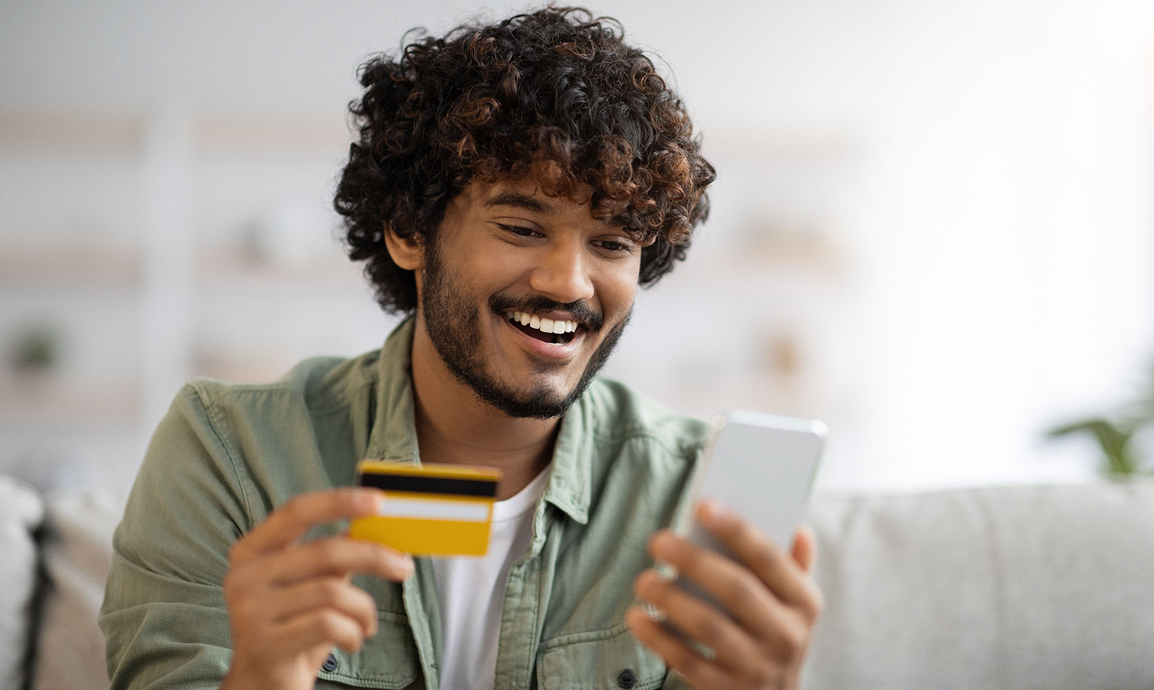 Happy man buying cheap canna dispensary weed online with his credit card. online dispensary Canada.