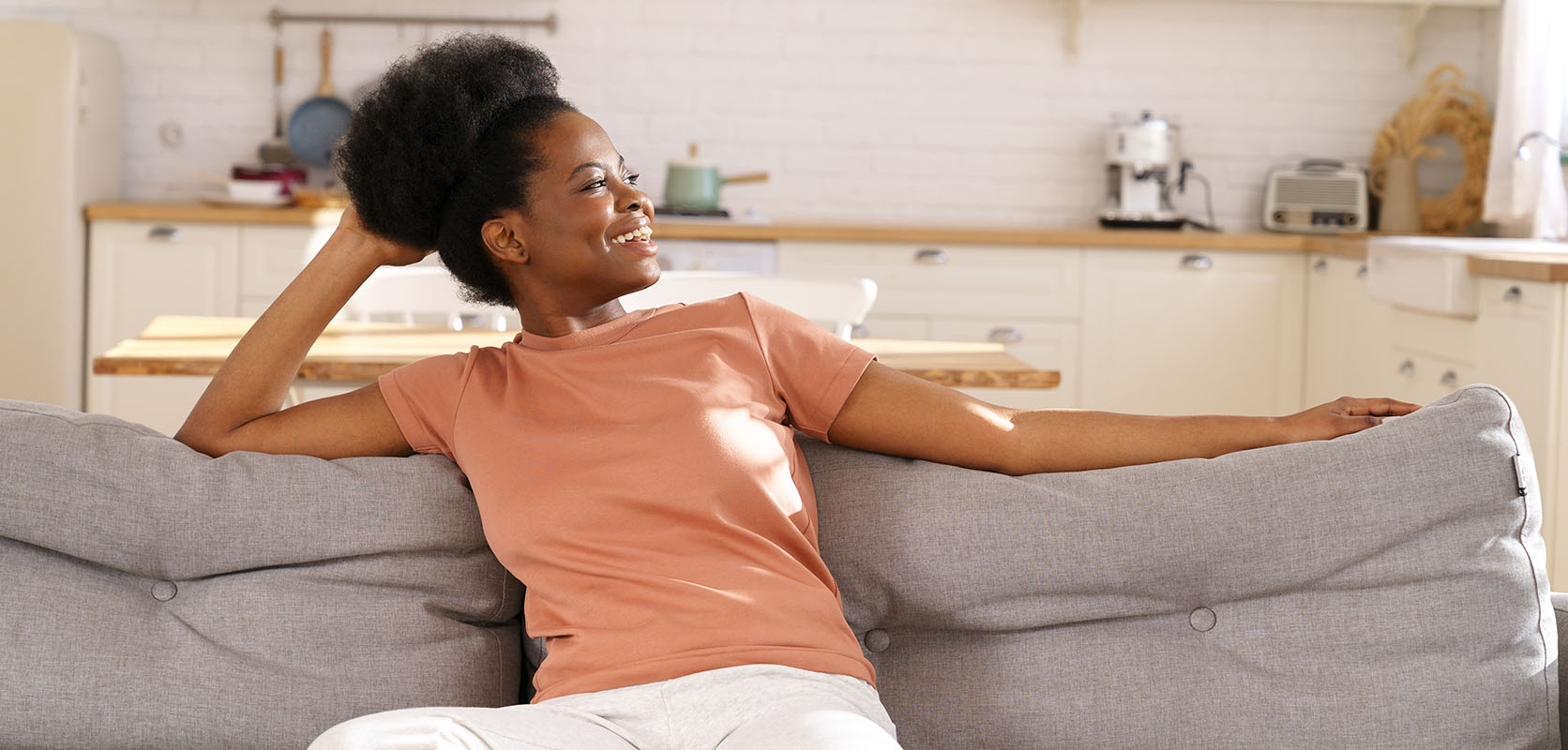 Happy, relaxed woman on her sofa at home after buying weed online value buds at Low Price Bud weed dispensary.