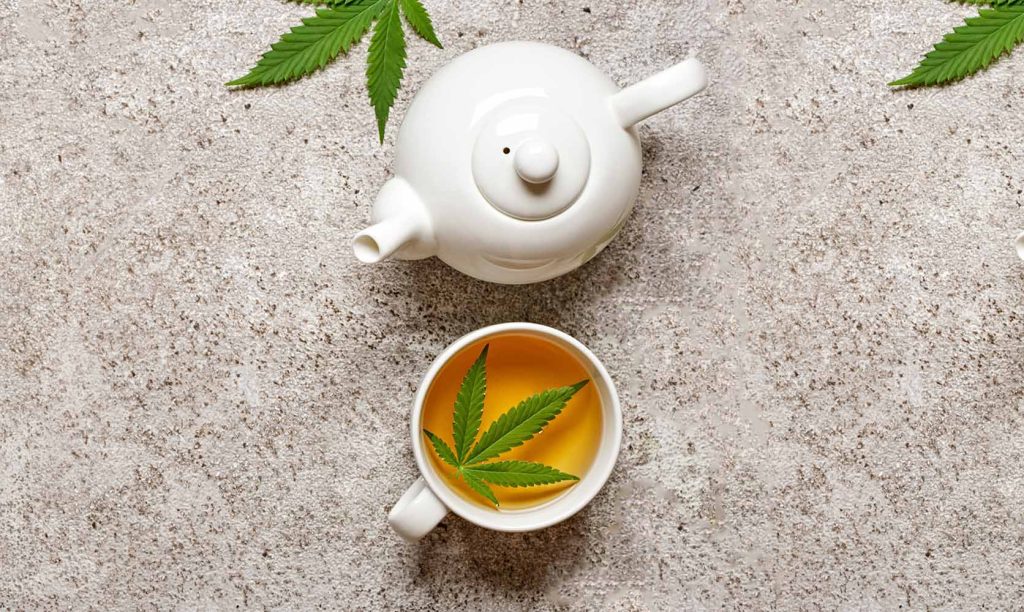 Weed tea in a tea pot with white tea cups and cannabis leaves made from BC bud online. Online dispensary for mail order marijuana.