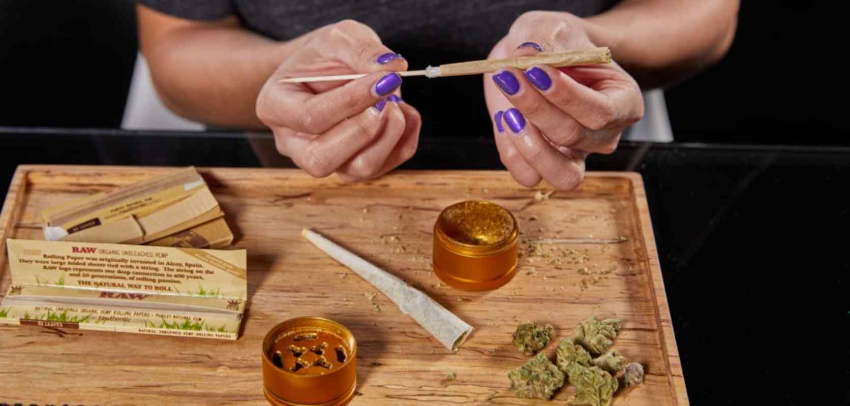 Woman learning how to make a cross joint and how to roll a cross joint with weed from an online dispensary in Canada.